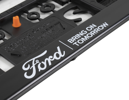 Suport pentru plăcuța de înmatriculare Ford  de culoare neagră, cu oval Ford și text „BRING ON TOMORROW”